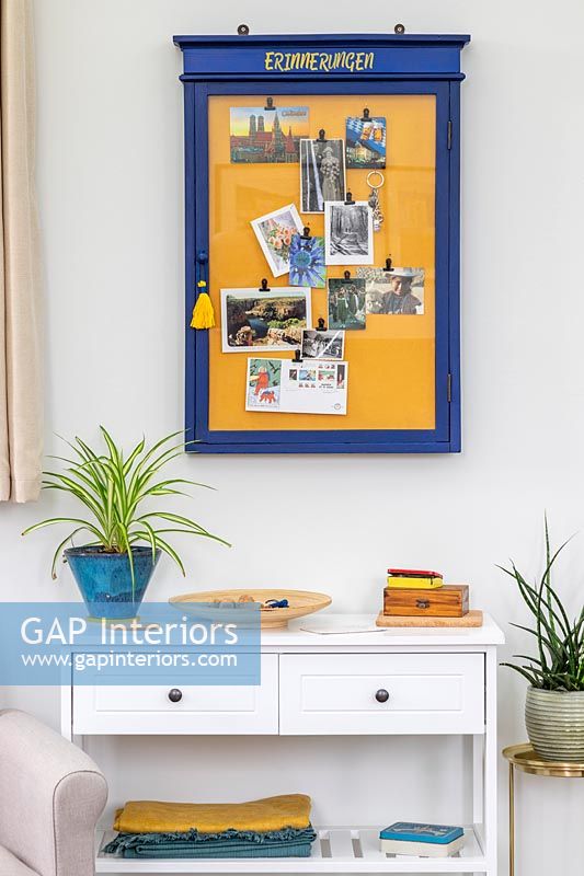 Blue and yellow notice board on wall of modern living room 