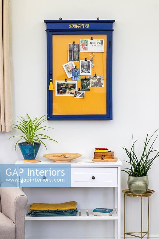 Blue and yellow notice board on modern living room wall 
