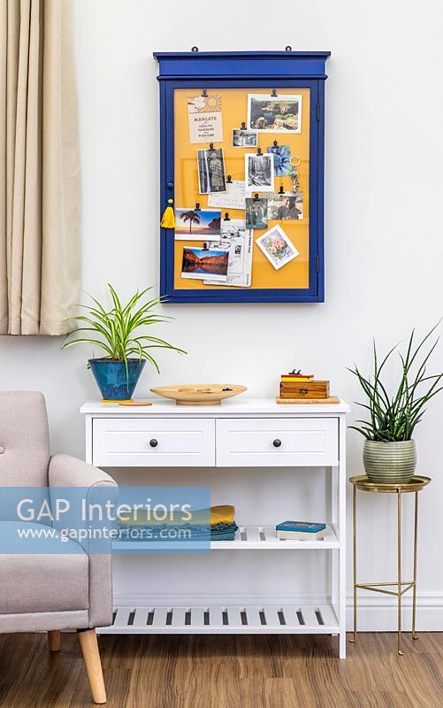 Blue and yellow framed notice board on modern living room wall 