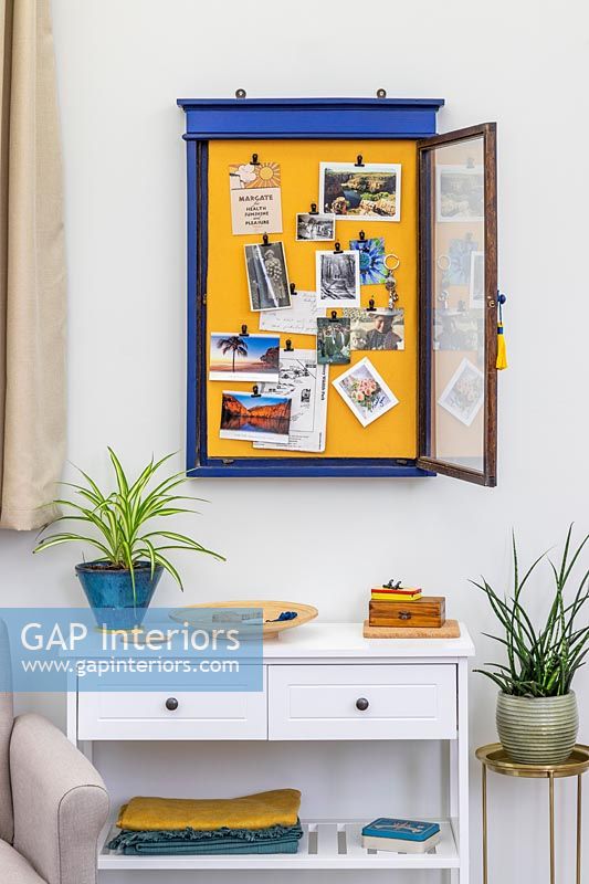 Blue and yellow framed notice board on modern living room wall 