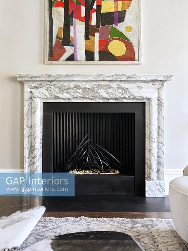 Marble fire surround and modern artwork above fireplace