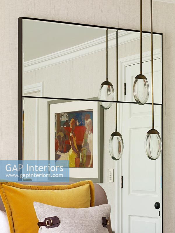 Large mirror with reflection of painting and pendant lights 