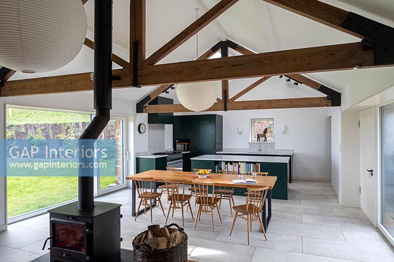 Modern country kitchen-diner with wood burning stove in centre