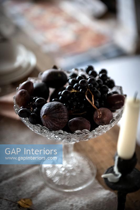 Dark coloured berries and figs in decorative glass bowl 