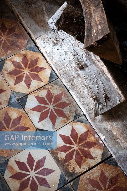 Aging floor tiles with red pattern detail 