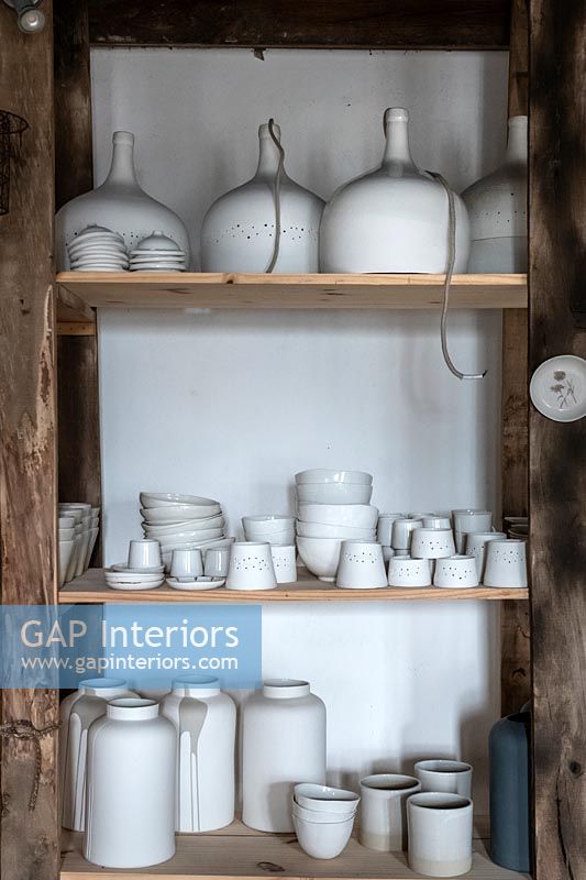 Display of white ceramics on wooden shelving 