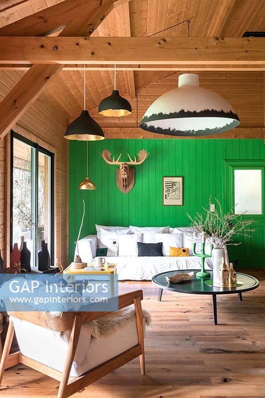 Modern country living room with bright green painted wooden feature wall 