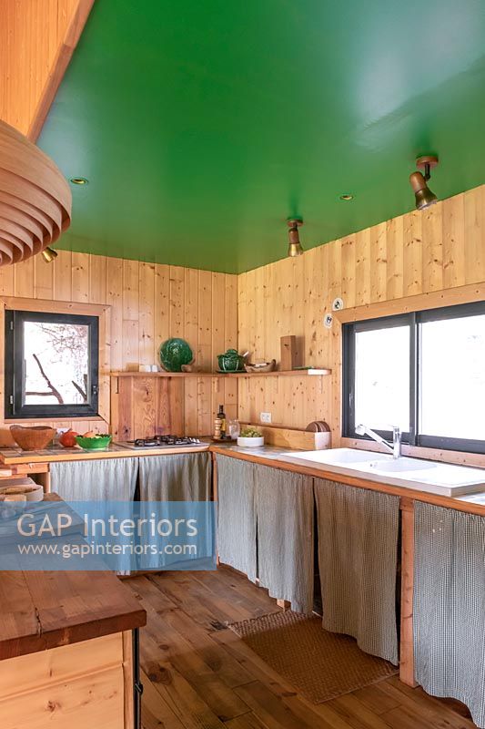 Wooden country kitchen with green painted ceiling 