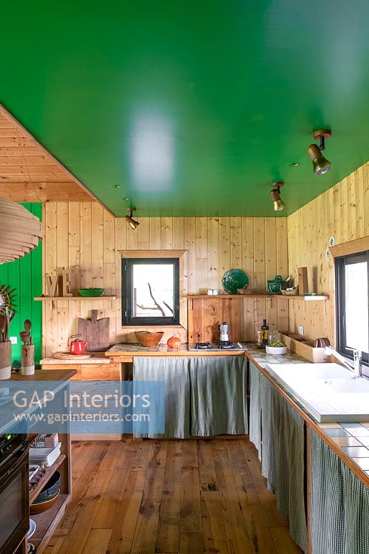 Wooden country kitchen with green painted ceiling