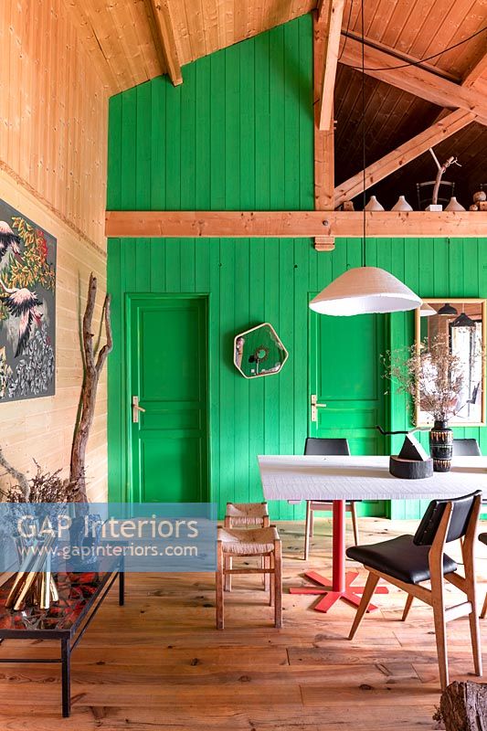 Green painted wooden feature wall in modern country dining room 