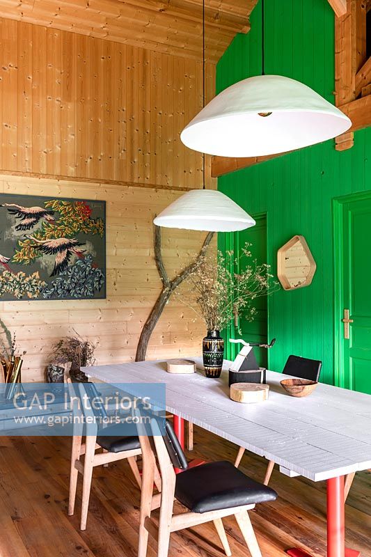 Country dining room with green painted wooden feature wall 