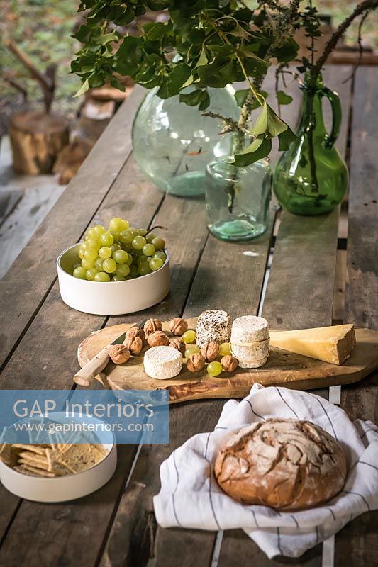 Bread and cheese on rustic outdoor dining table 