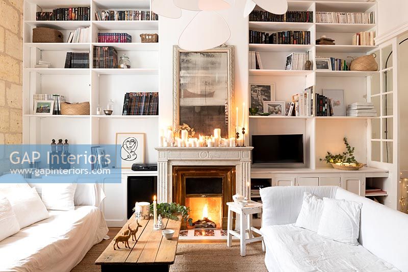 Lit fireplace in white living room at Christmas 