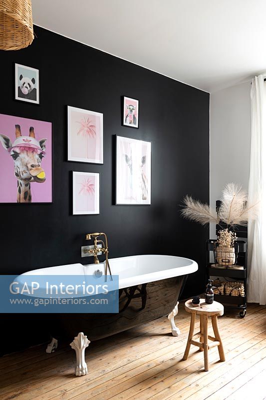 Black painted feature wall in modern bathroom with roll top bath