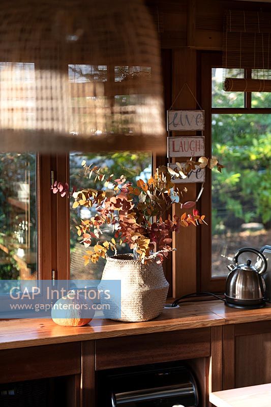 Dried flower arrangement in large pot by window of country kitchen 