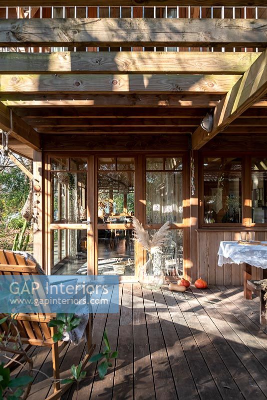 Seating area on wooden decked terrace of country cabin 
