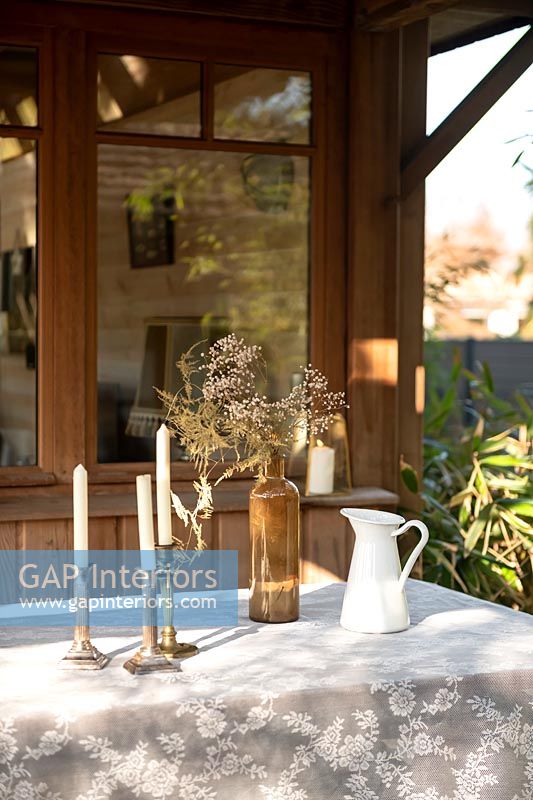 Candlesticks on outdoor dining table covered with lace tablecloth