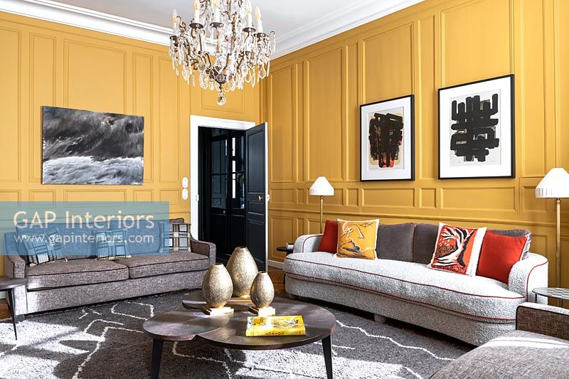 Modern living room with yellow painted panelled walls 