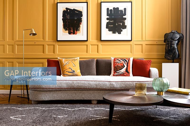 Yellow painted panelled walls in modern living room 
