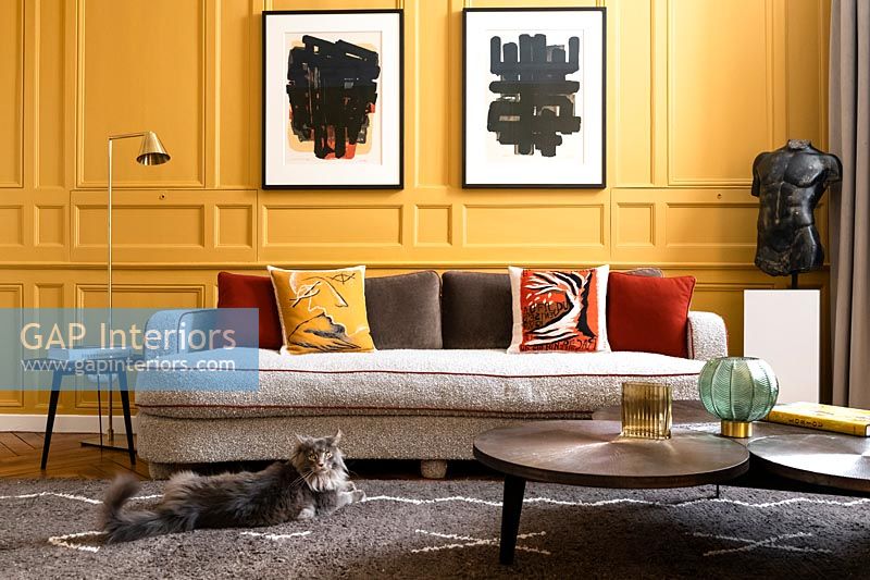 Pet cat in modern living room with yellow painted panelled walls 