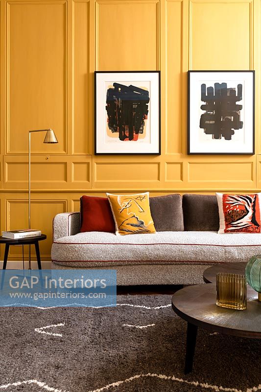 Sofa in front of colourful yellow wall