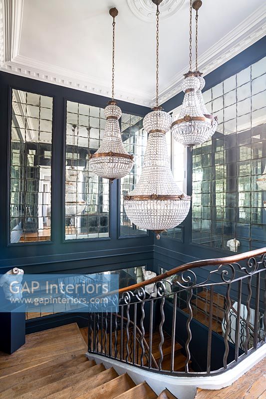Chandeliers over classic staircase with mirrored walls 