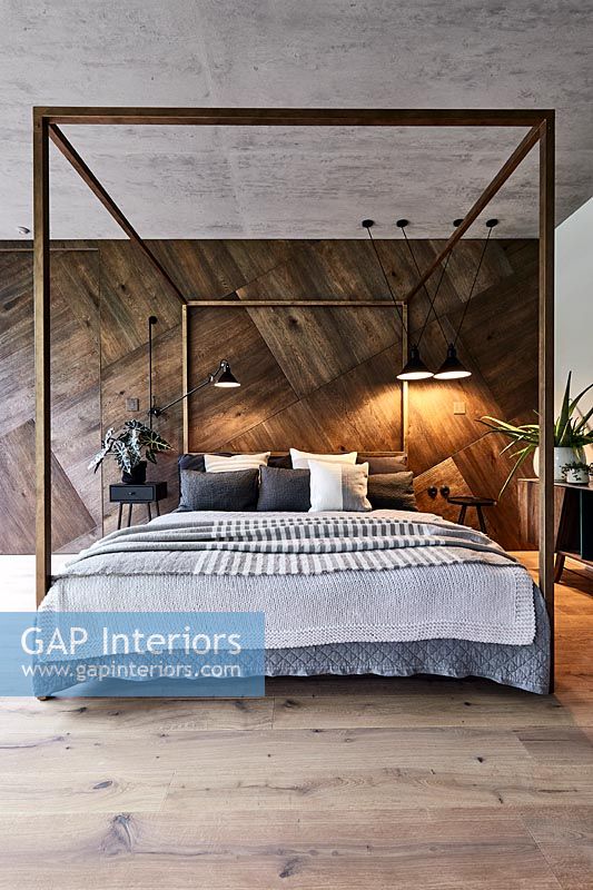 Modern bedroom with wooden wall and fourposter bed 