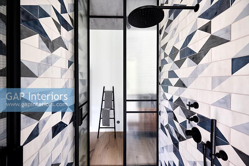 Modern wet room with patterned tiling on wall 