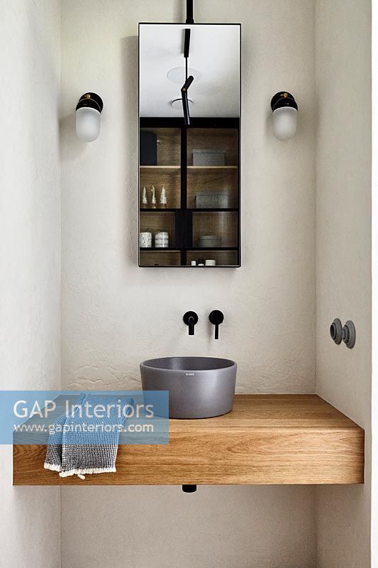 Grey bathroom sink on large wooden shelf