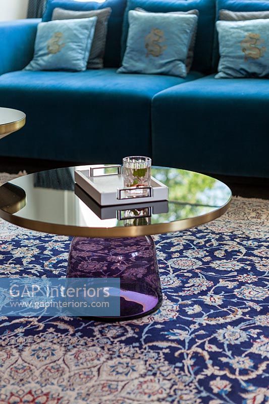 Unusual purple glass and metal side table on patterned rug 