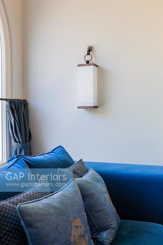 Hanging wall light next to modern blue sofa 