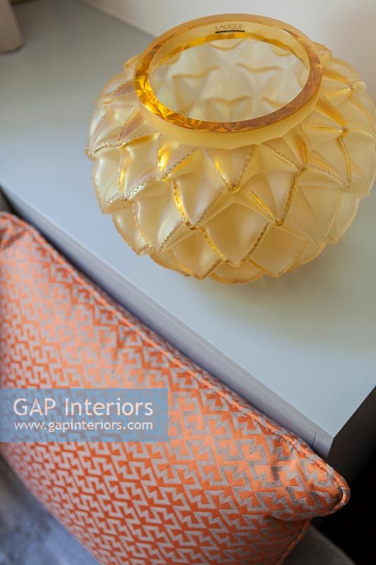 Ornate orange glassware next to patterned pillow - detail 