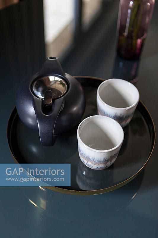 Black tea pot with small ceramic white cups 