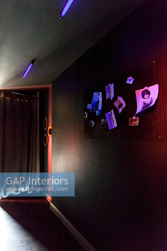 Illuminated neon lighting and pictures in black painted corridor 