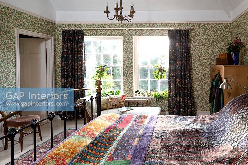 Patterned wallpaper, bedding and curtains in country bedroom 