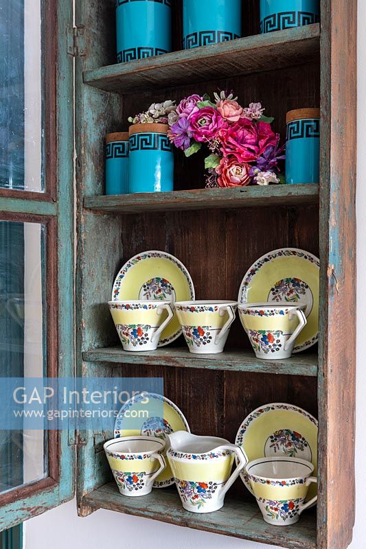 Display of vintage tea set and storage jars in wall mounted cabinet 