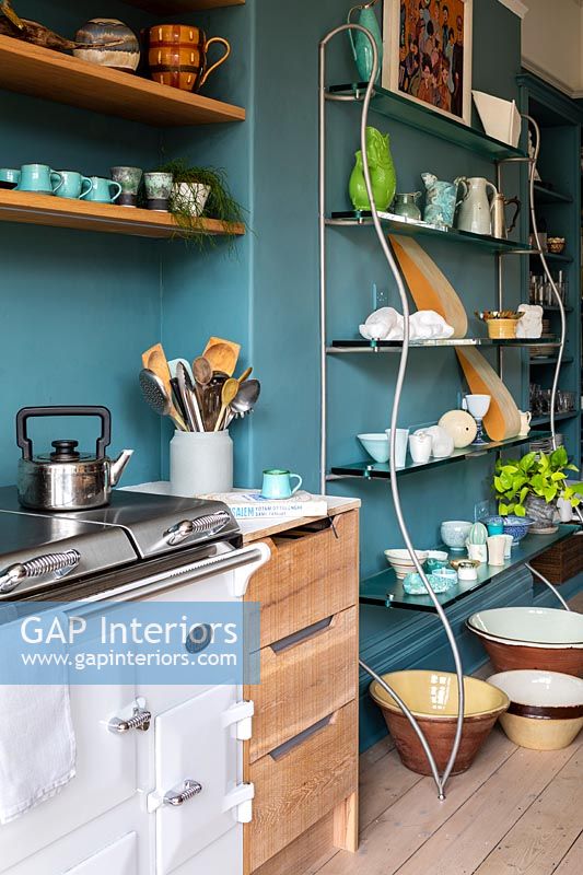 Aga style stove in modern kitchen with teal blue painted walls 