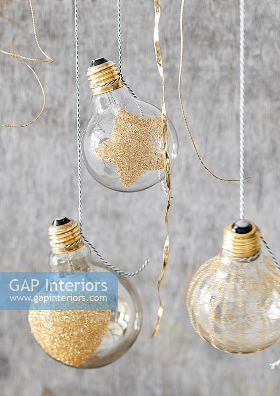 Lightbulb baubles decorated with gold glitter 