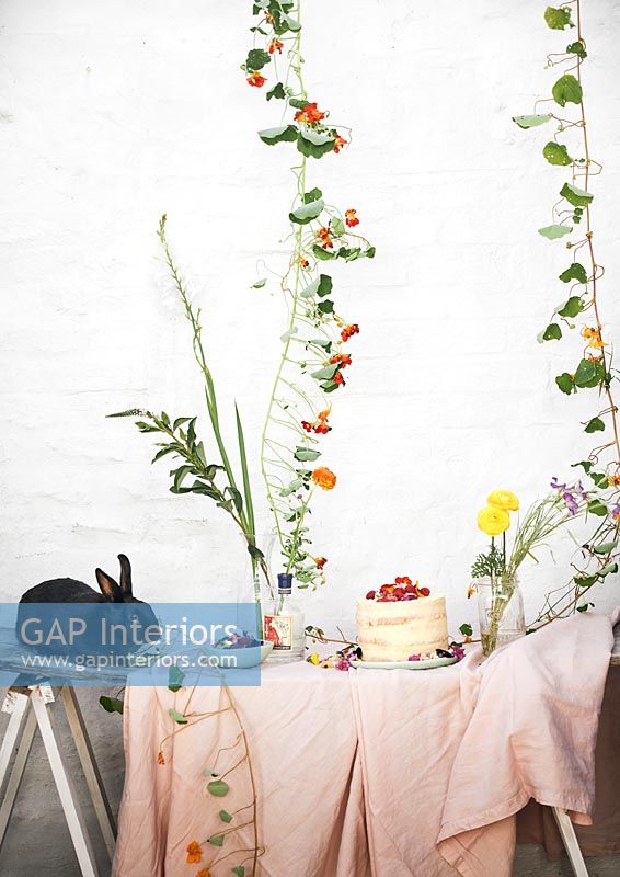 Pet rabbit on garden table filled with flowers