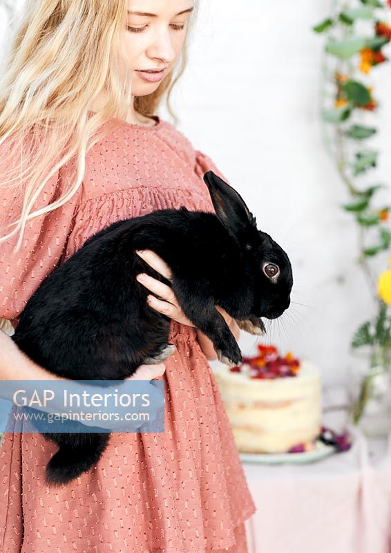 Young woman holding pet rabbit 