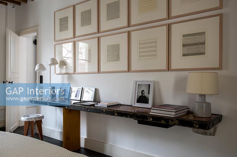 Display of framed pictures on wall above floating table