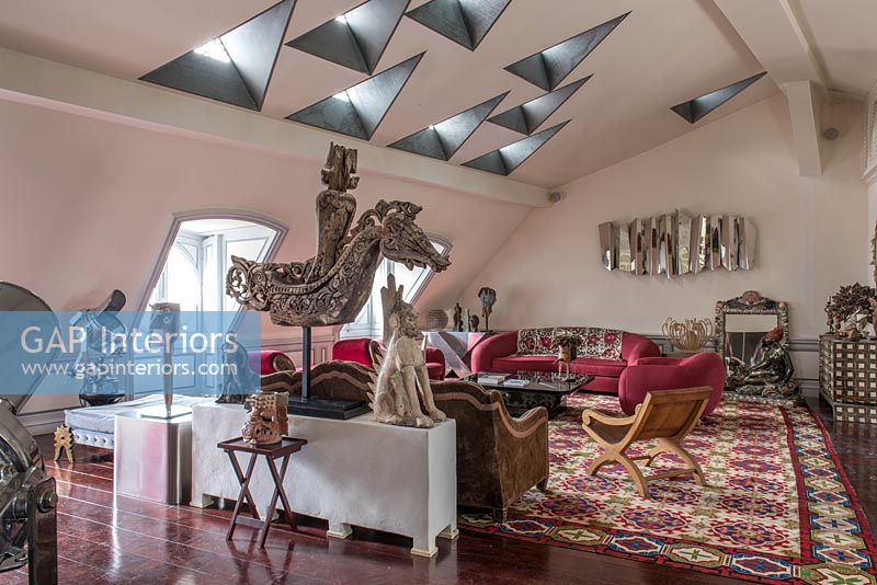 Eclectic living room with unusual triangular skylights 
