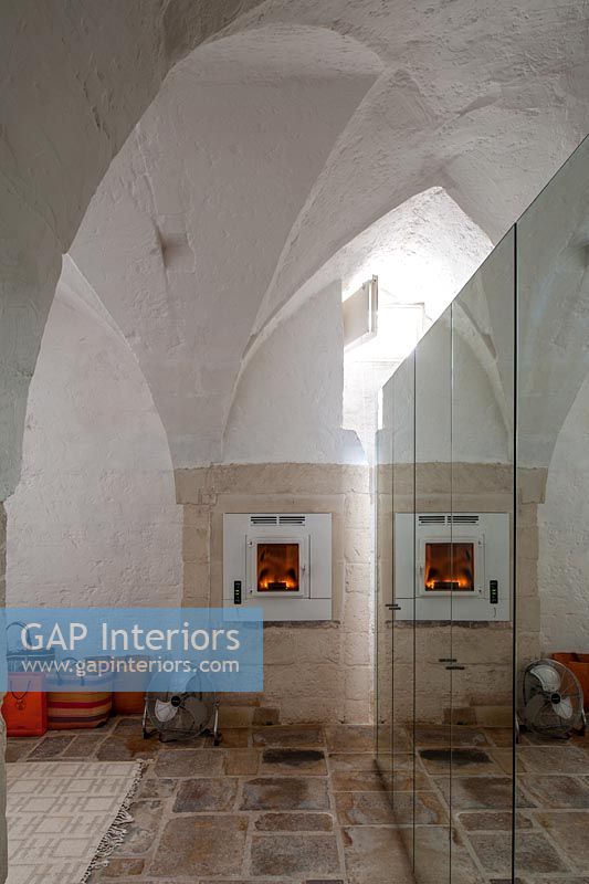 Lit fire set into stone wall with vaulted ceilings 