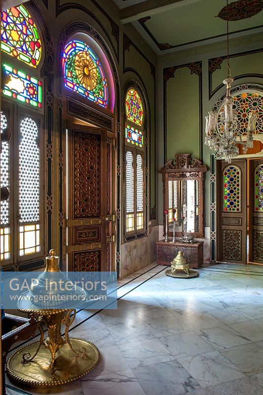 Ornate carved front door and stained glass windows in grand hallway 