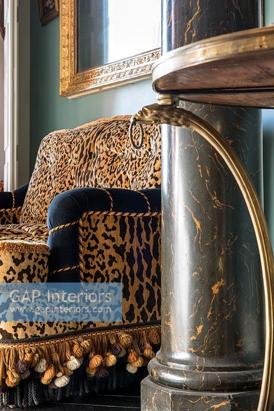 Leopard print sofa and marble column in eclectic living room 