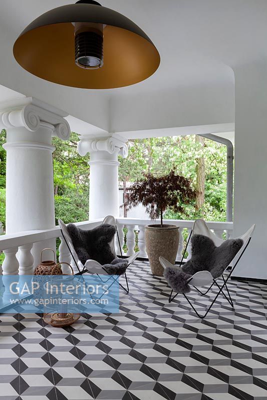 seating area on modern balcony with black and white illusion flooring 