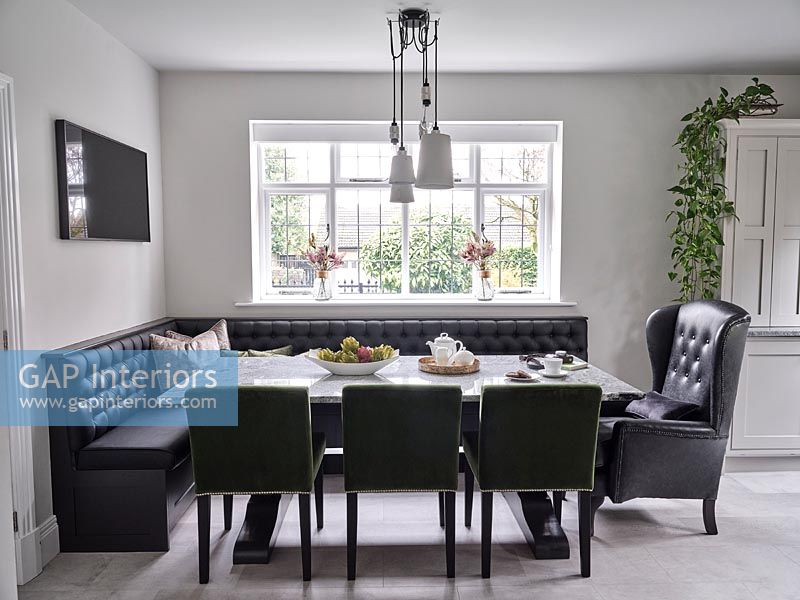 Black leather corner bench seating around dining table 