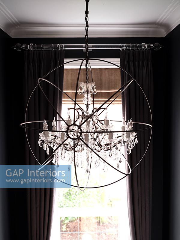 Detail of modern chandelier and black painted walls 