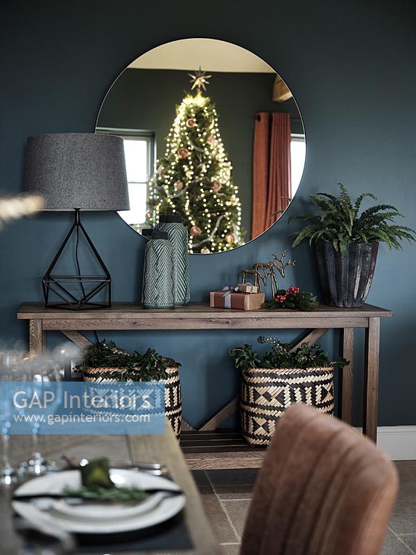 Reflection of Christmas tree in round dining room mirror 