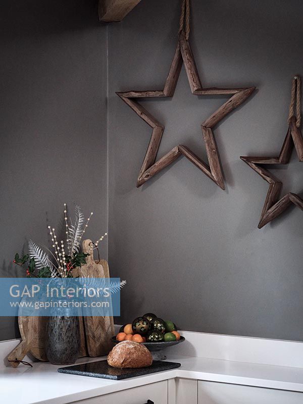 Wooden star decorations on grey painted modern kitchen wall 